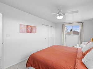 Carpeted bedroom with a closet and ceiling fan