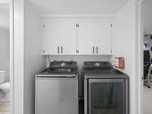 Washroom featuring washer and dryer and cabinets