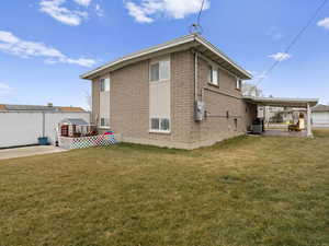 Back of house with a patio and a lawn