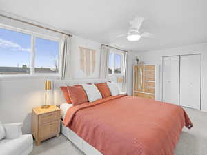 Bedroom featuring ceiling fan, light carpet, and a closet