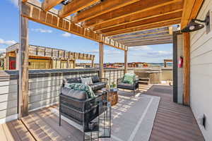 Wooden terrace featuring an outdoor hangout area, a pergola, and a hot tub