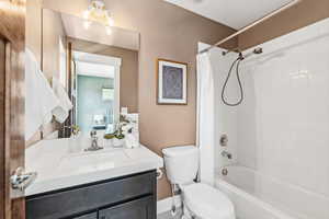 Full bathroom featuring toilet, vanity, and shower / tub combo