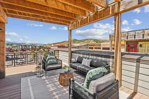 Wooden terrace featuring an outdoor hangout area, a mountain view, and a pergola