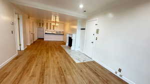 Interior space featuring a notable chandelier, light hardwood / wood-style flooring, and ornamental molding