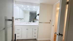 Bathroom with hardwood / wood-style floors, an enclosed shower, and vanity