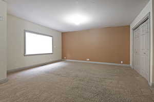 Unfurnished bedroom with a closet and light colored carpet