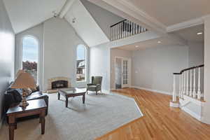 Sitting room with beamed ceiling, high vaulted ceiling, and hardwood / wood-style floors