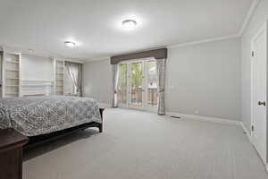 Bedroom featuring carpet, access to exterior, and crown molding