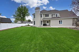 Back of property featuring a lawn and a patio area