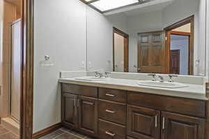 Bathroom featuring vanity, an enclosed shower, and tile patterned floors