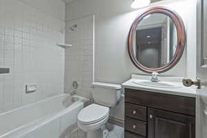 Full bathroom featuring tiled shower / bath combo, vanity, tile patterned flooring, and toilet