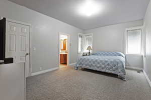 Bedroom with ensuite bathroom and carpet