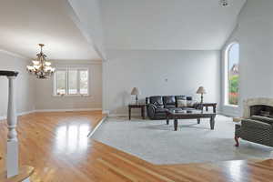 Living room with light wood-type flooring, crown molding, and a chandelier