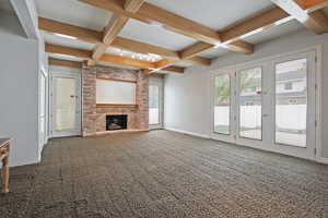 Unfurnished living room featuring coffered ceiling, a brick fireplace, and carpet flooring