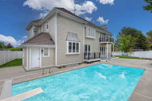 Back of house featuring a patio area, a balcony, and a pool side deck