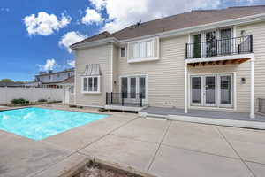 Exterior space featuring a balcony, a patio area, and a fenced in pool