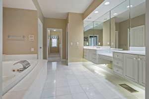 Bathroom with tile patterned floors, vanity, and independent shower and bath