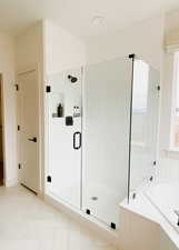 Bathroom featuring shower with separate bathtub and tile patterned flooring