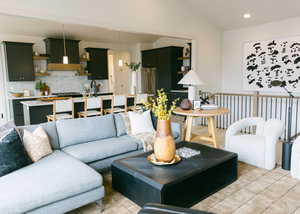 Tiled living room with sink and vaulted ceiling