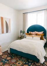 Carpeted bedroom featuring multiple windows