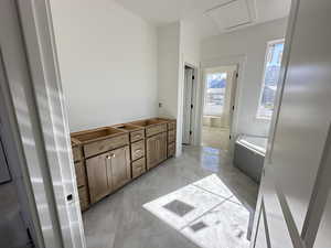 Bathroom featuring a garden tub and marble finish floor