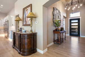 Entrance foyer featuring light wood-type flooring and a chandelier