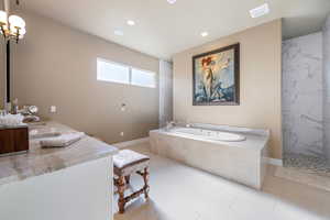 Bathroom featuring tile patterned floors, separate shower and tub, dual sinks, and a chandelier