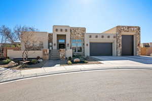 Pueblo-style house featuring a garage