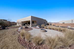 Rear view of house featuring a fire pit and a patio area