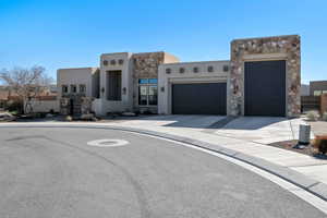 Pueblo-style house featuring a garage