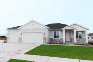 View of front facade featuring a garage and a front lawn