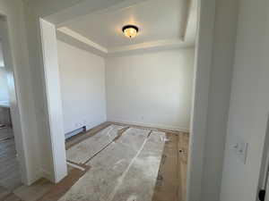 Spare room with baseboards and a raised ceiling
