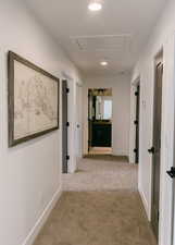 Hallway featuring light carpet