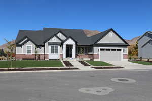 View of front of house with a mountain view, a front yard, and a garage