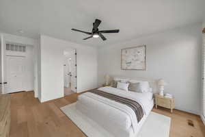 Bedroom featuring light wood-style flooring, a ceiling fan, and ensuite bathroom