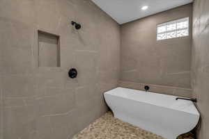 Bathroom with a tub to relax in and tile walls