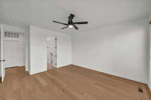 Unfurnished bedroom with ceiling fan and light wood-type flooring