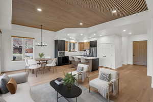 Living area featuring a chandelier, light wood finished floors, recessed lighting, and wooden ceiling