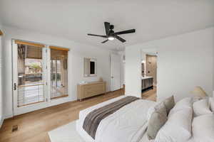 Bedroom featuring access to exterior, light wood-style floors, a ceiling fan, and ensuite bath