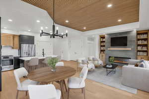 Dining room featuring recessed lighting, a tiled fireplace, wooden ceiling, a chandelier, and light wood-type flooring