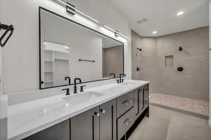 Bathroom with vanity and tiled shower