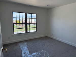 Carpeted empty room with baseboards, visible vents, and a textured ceiling