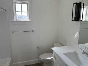 Bathroom with a bath, vanity, a shower, baseboards, and toilet
