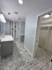 Bathroom with a textured ceiling, a shower with shower curtain, and vanity