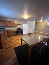 Kitchen with a textured ceiling, stainless steel appliances, and light hardwood / wood-style floors