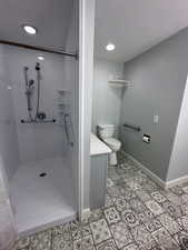 Bathroom with toilet, a textured ceiling, and walk in shower