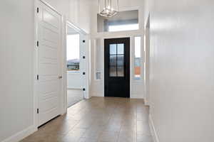 Tiled entryway with a chandelier