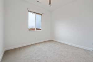 Carpeted empty room featuring ceiling fan