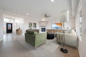 Tiled living room with ceiling fan and a large fireplace