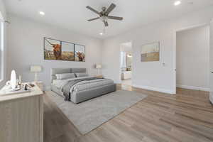 Bedroom with light hardwood / wood-style floors, ensuite bath, and ceiling fan